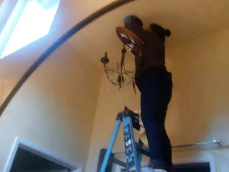 Electrician installing a chandelier in a Napa residence